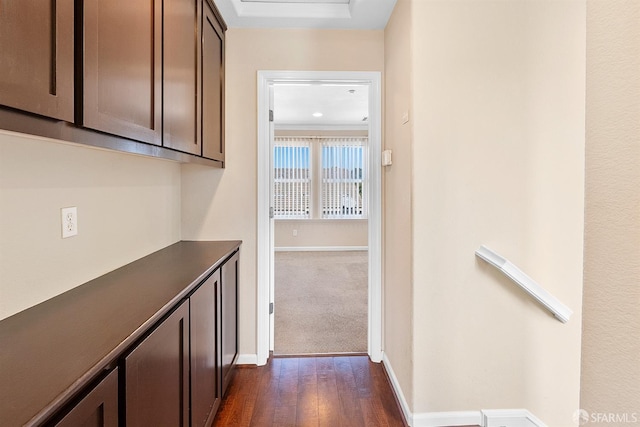 corridor with baseboards and dark wood-type flooring