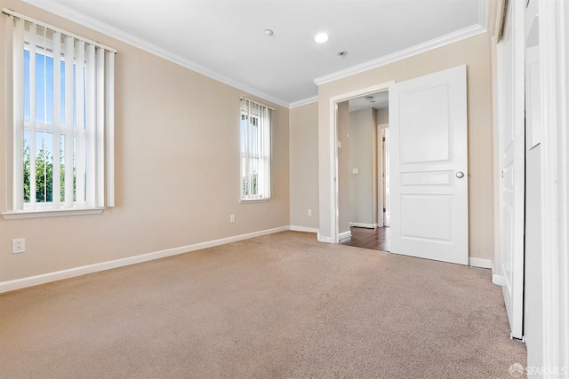 unfurnished bedroom with ornamental molding, multiple windows, carpet, and baseboards