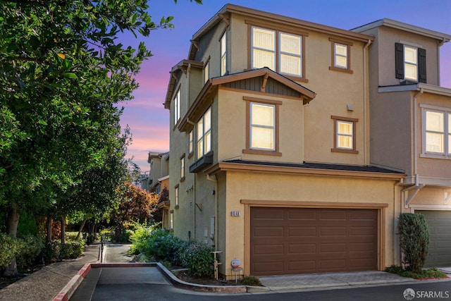 multi unit property featuring a garage and stucco siding