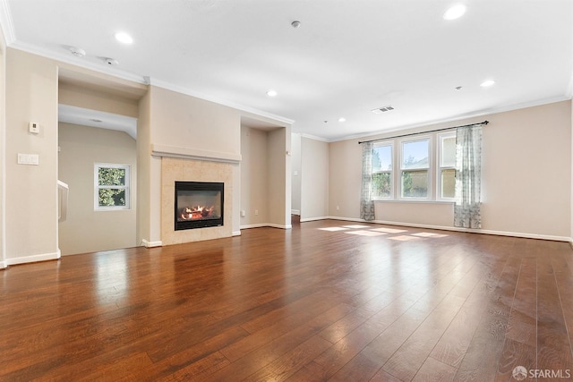 unfurnished living room with plenty of natural light, crown molding, and hardwood / wood-style flooring