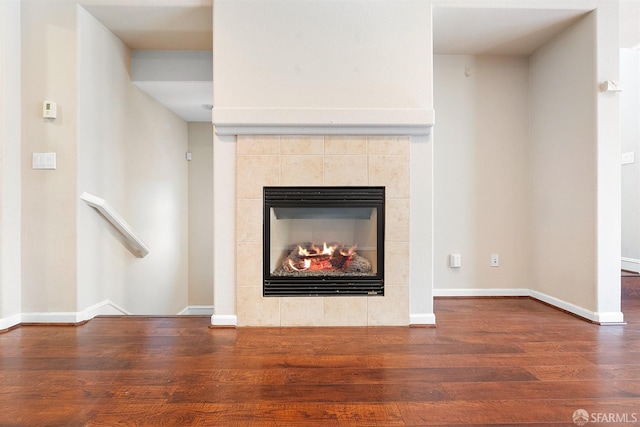 room details with a fireplace, baseboards, and wood finished floors