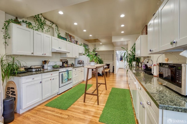 kitchen with light hardwood / wood-style flooring, gas range gas stove, and white cabinets