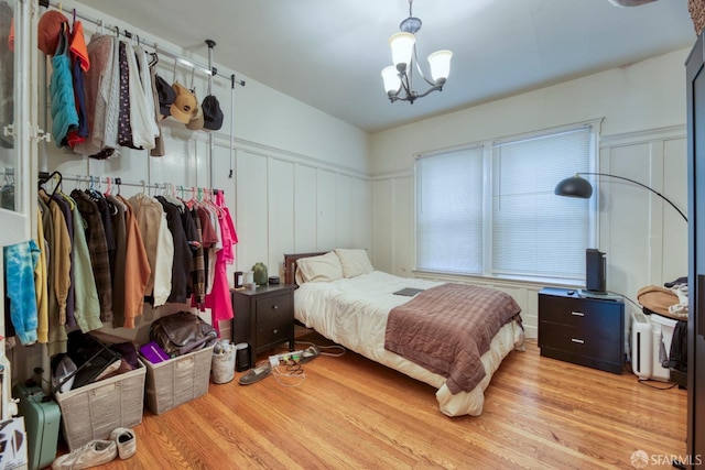 bedroom with a chandelier and light hardwood / wood-style flooring