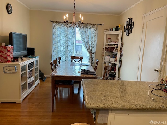 dining space with ornamental molding, dark hardwood / wood-style floors, and an inviting chandelier