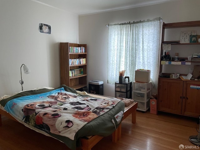 bedroom featuring crown molding and light wood-type flooring