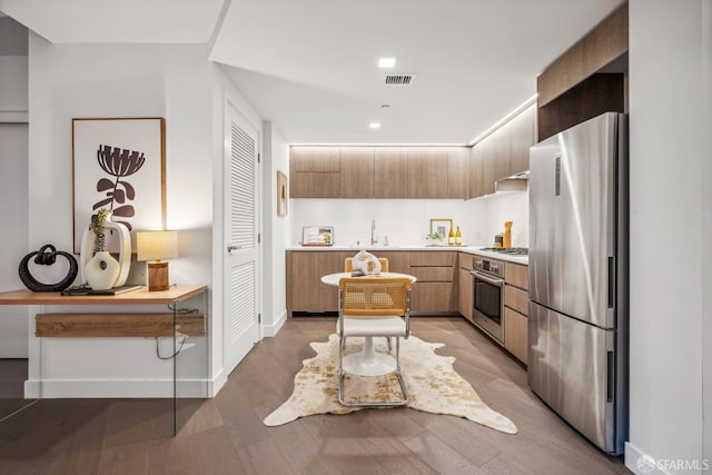 kitchen featuring light brown cabinets, stainless steel appliances, hardwood / wood-style flooring, and sink