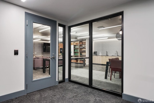 doorway to outside with dark carpet