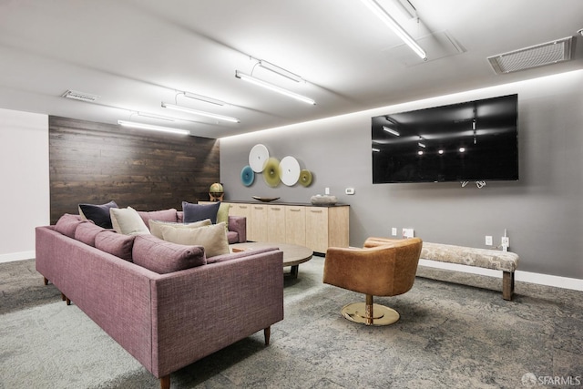 carpeted living room featuring wood walls