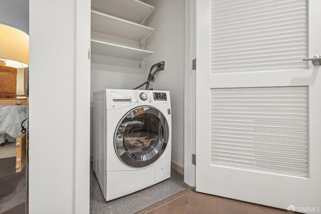 laundry room with hardwood / wood-style flooring and washer / dryer