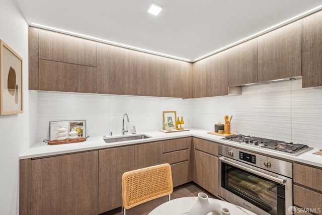 kitchen with decorative backsplash, sink, and appliances with stainless steel finishes