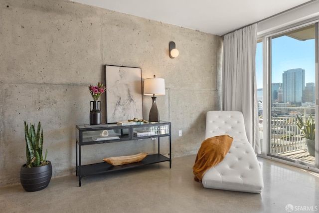 living area featuring plenty of natural light, a skyline view, and concrete floors