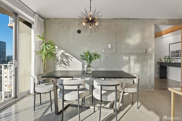 dining room with a chandelier, concrete floors, and healthy amount of natural light