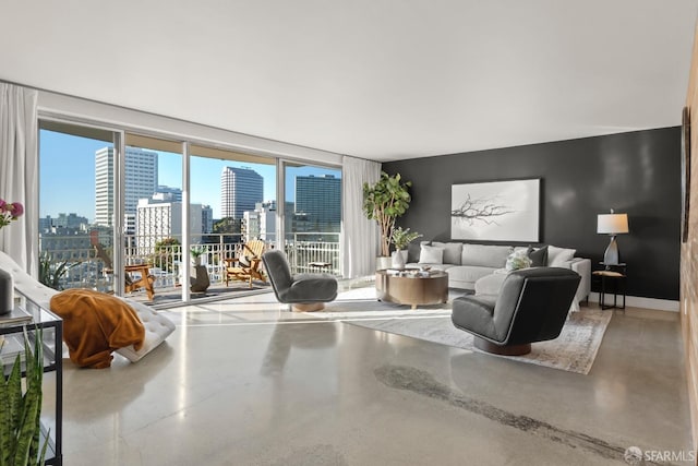 living area with a view of skyline, finished concrete flooring, and baseboards
