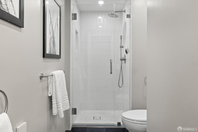 bathroom with a stall shower and toilet