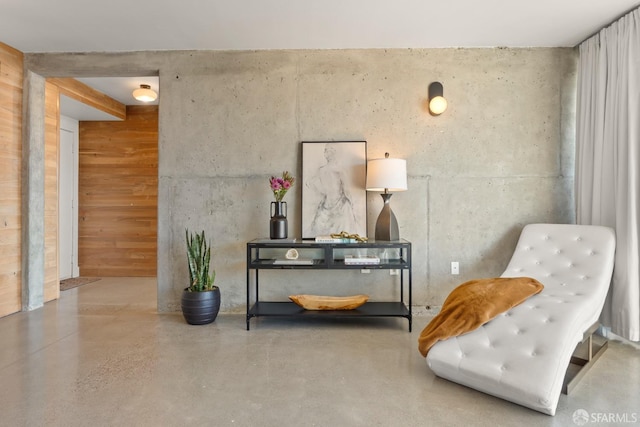 sitting room with wooden walls and concrete floors