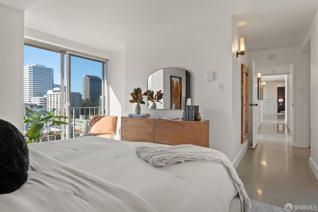 bedroom with baseboards and a skyline view