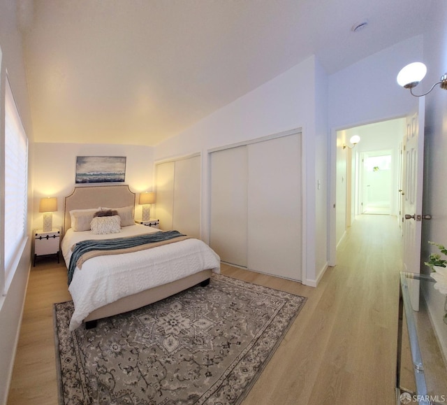 bedroom featuring light hardwood / wood-style flooring and lofted ceiling