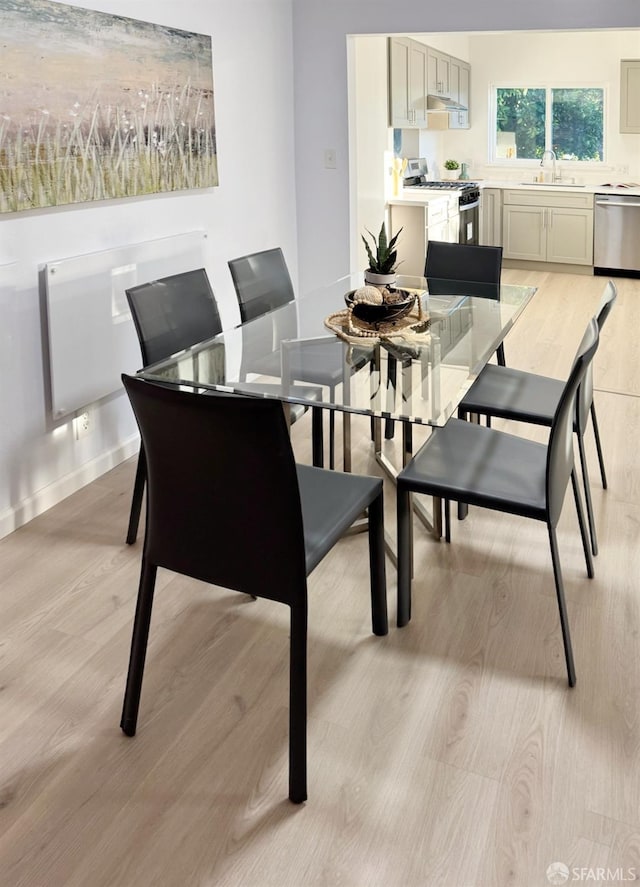 dining space with light hardwood / wood-style floors and sink