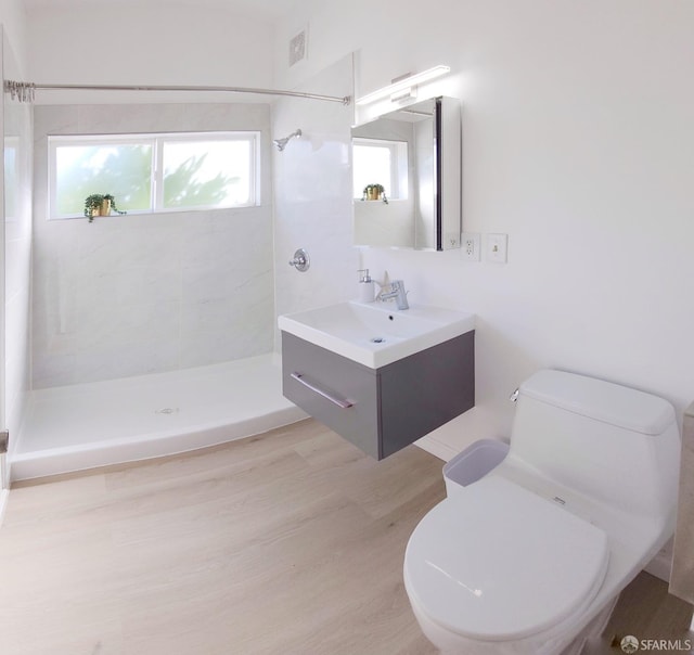 bathroom featuring vanity, toilet, and tiled shower