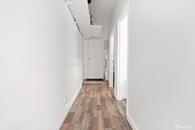 hall featuring light wood-type flooring and baseboards