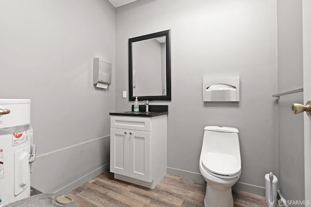 bathroom with toilet, wood finished floors, baseboards, and water heater