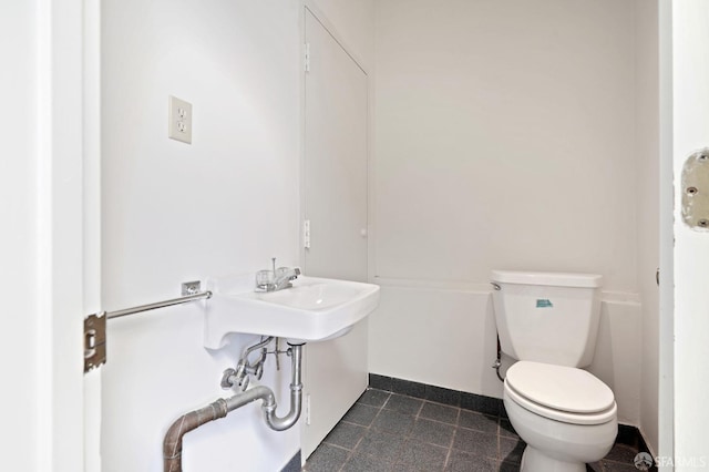 bathroom with baseboards and toilet