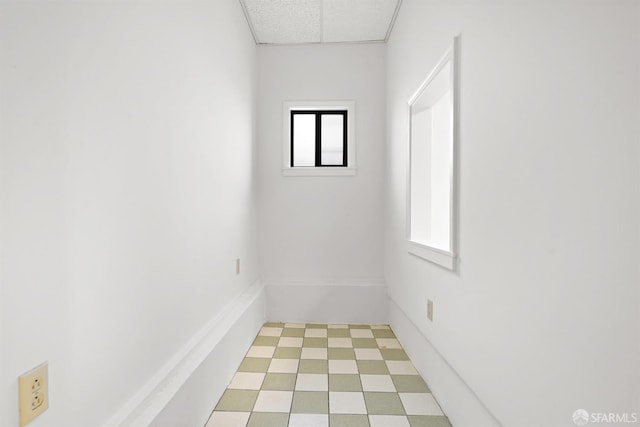 unfurnished room featuring a paneled ceiling and light floors