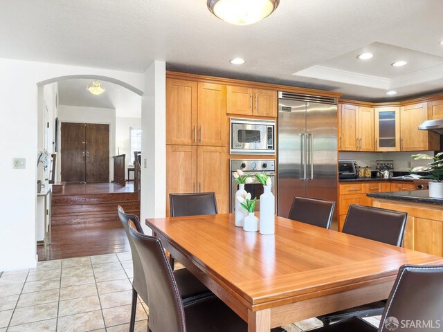 1113 Pebblewood Way, San Mateo, CA 94403 - dining room featuring recessed lighting, light tile patterned floors, a tray ceiling, crown molding, and arched walkways