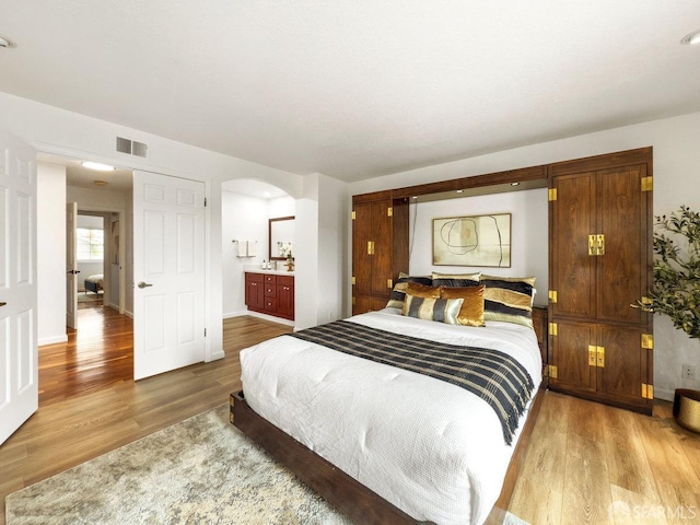1113 Pebblewood Way, San Mateo, CA 94403 - bedroom with connected bathroom, visible vents, baseboards, arched walkways, and wood finished floors