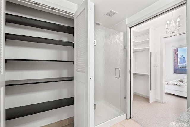 bathroom with a stall shower and visible vents