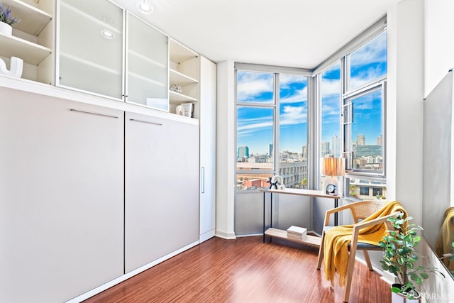 living area with a view of city and wood finished floors