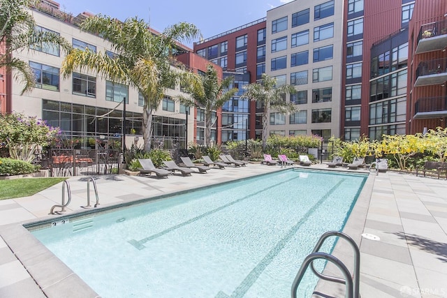 community pool with fence and a patio