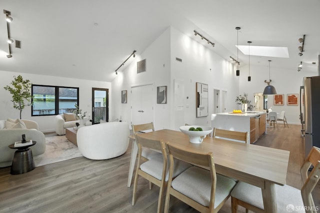 206 Donohoe St, East Palo Alto, CA 94303 - dining room featuring rail lighting, a skylight, high vaulted ceiling, and wood finished floors