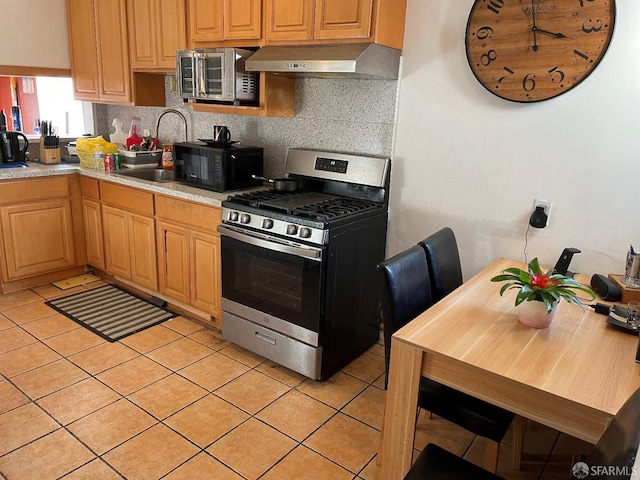 kitchen with stainless steel appliances, extractor fan, sink, and light tile patterned floors