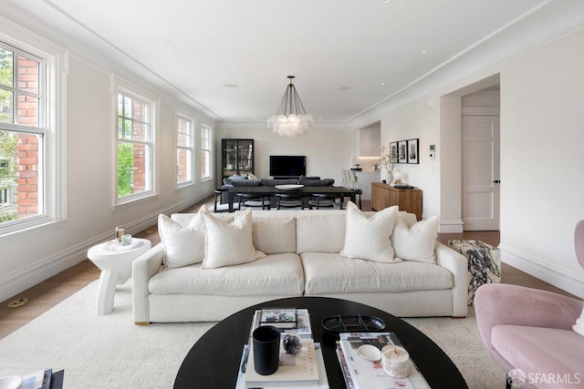 living room with baseboards, wood finished floors, and crown molding