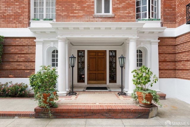 view of exterior entry with brick siding