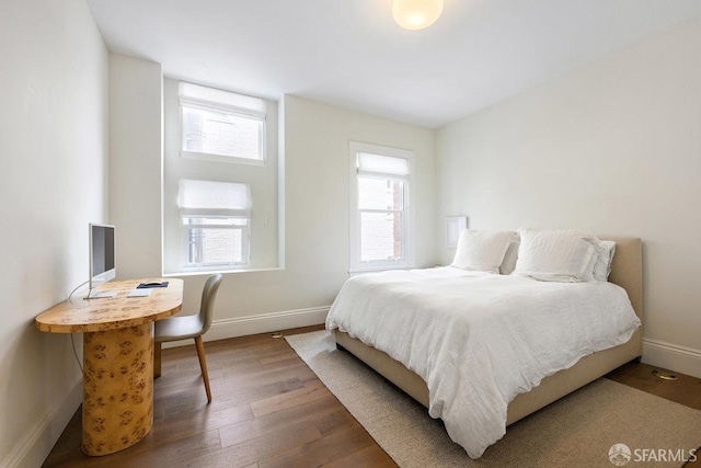 bedroom with wood finished floors and baseboards