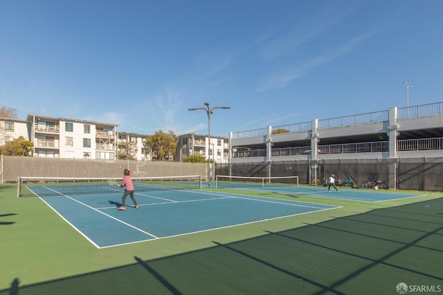 view of tennis court with basketball hoop