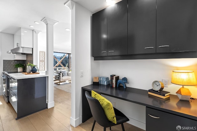 kitchen featuring backsplash, electric stove, built in desk, light hardwood / wood-style floors, and white cabinetry