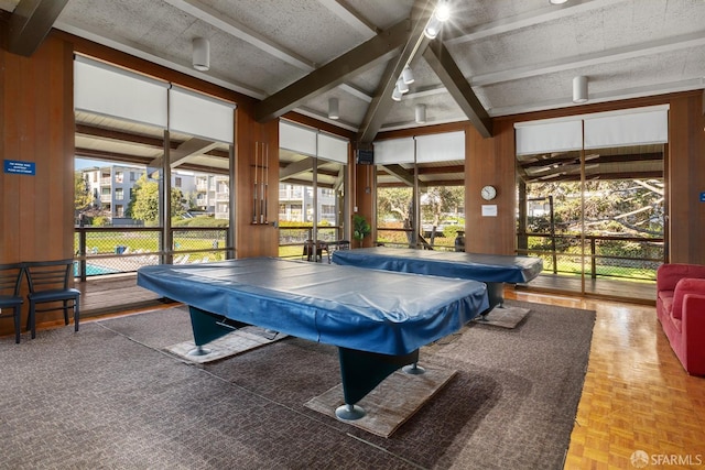 rec room with parquet flooring, lofted ceiling with beams, wooden walls, and pool table