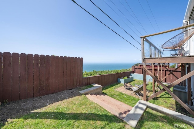 view of yard with an outdoor fire pit, a water view, and fence private yard