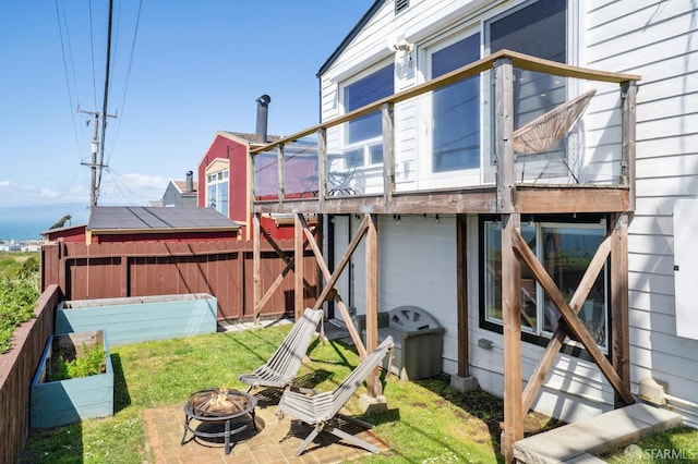 exterior space featuring an outdoor fire pit and fence