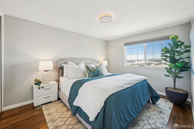 bedroom featuring baseboards and wood finished floors