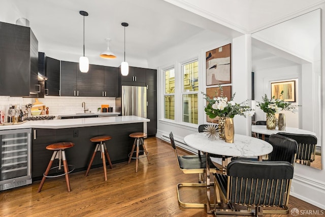 213 Virginia Ave, San Francisco, CA 94110 - kitchen with beverage cooler, a peninsula, a breakfast bar area, light countertops, and freestanding refrigerator