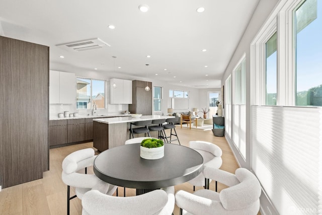 dining area featuring sink and light hardwood / wood-style flooring