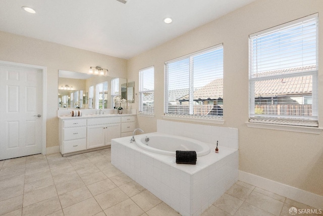 bathroom with tiled bath, tile patterned flooring, and vanity