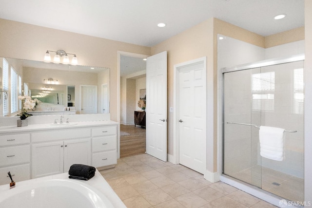 bathroom with tile patterned flooring, separate shower and tub, and vanity