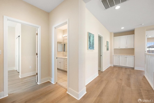 corridor featuring light hardwood / wood-style floors and sink