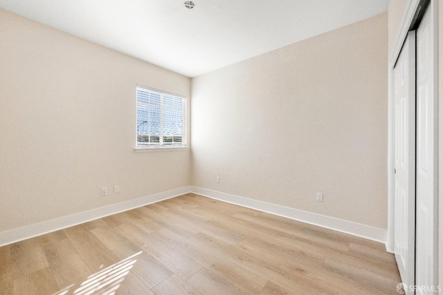 unfurnished bedroom featuring light wood-type flooring and a closet