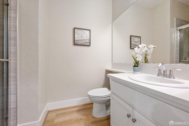 bathroom featuring toilet, a shower with door, wood-type flooring, and vanity